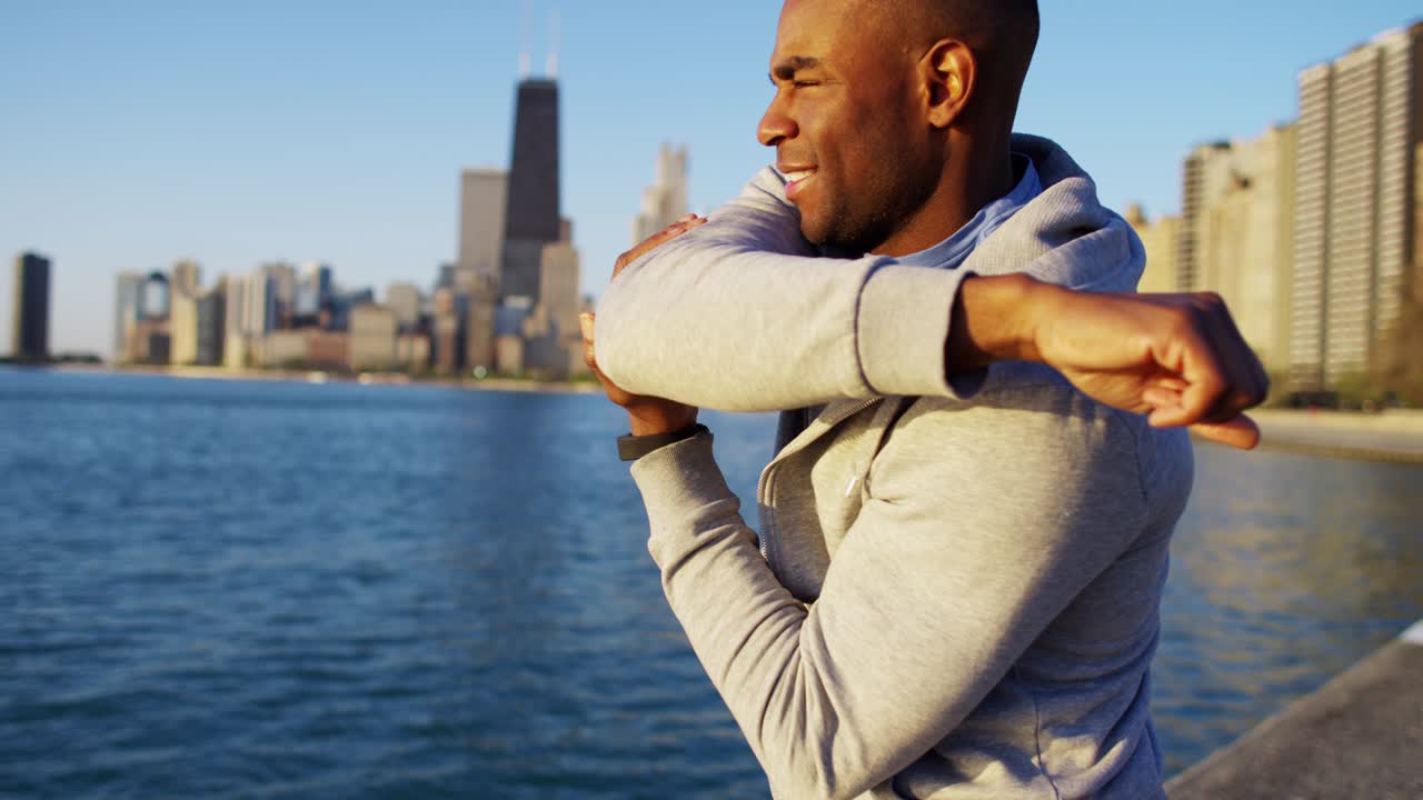 hombre afroamericano sano estirándose y descansando al aire libre