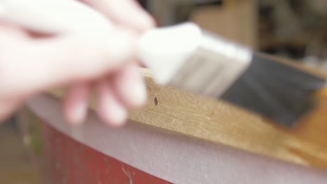 Brushing-Danish-oil-finish-onto-Teak-boat-gunwale