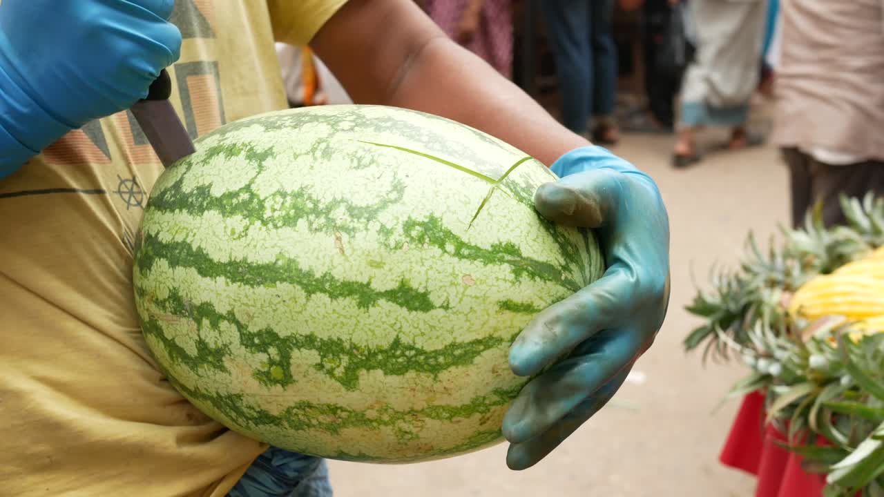젊은 남자 들 이 야외 에서 수박 을 자르고 있다
