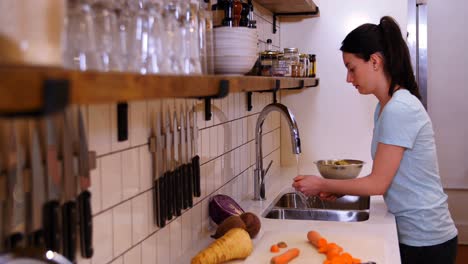 Mujer-Lavando-Zanahoria-En-El-Fregadero-De-La-Cocina