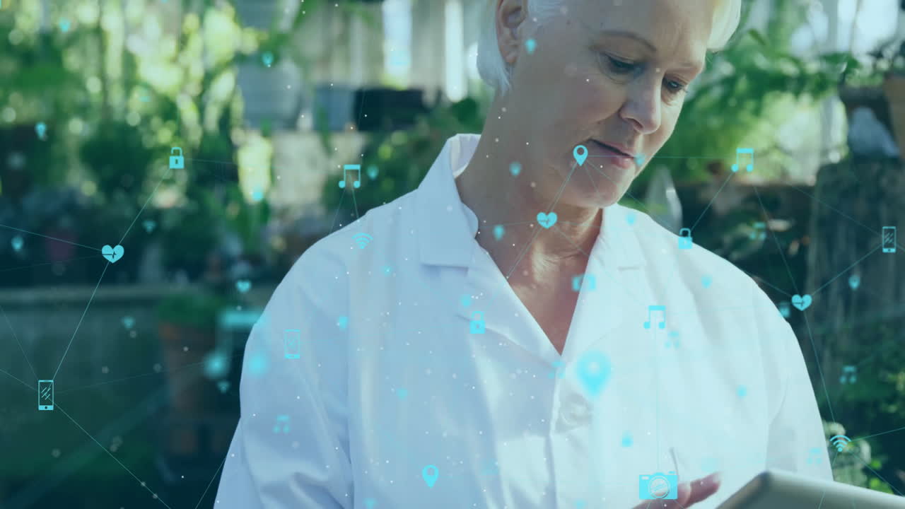 Using tablet with animation overlay, elderly woman in white coat in office