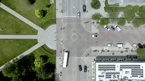 Iowa-City,-Iowa-downtown-intersection-with-traffic-moving-and-drone-video-overhead-stable