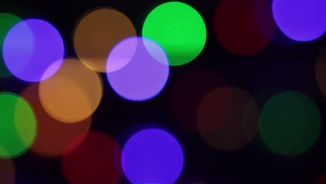el fondo borroso de navidad. círculos de colores brillantes desenfocados luces de navidad video. luz multicolor filtra imágenes de 4k en fondo negro. feliz año nuevo