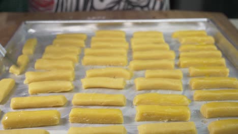 woman chef greases the cookie dough with egg yolks using a brush