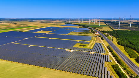 rural solar and wind fields. solar panels stretch across fields while wind turbines stand tall against a clear blue sky, showcasing renewable energy