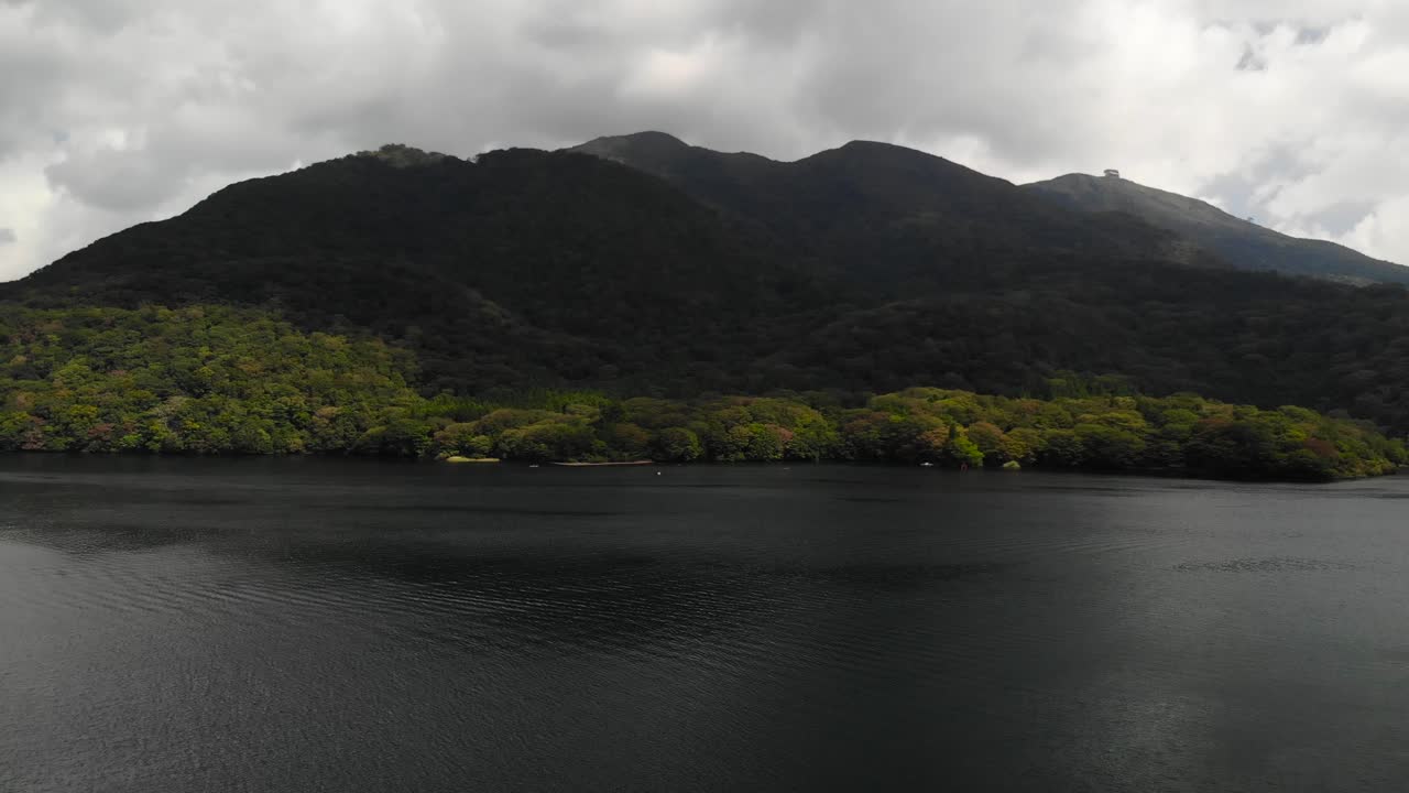 거리에 숲 산들과 변덕스러운 호수 위로 공중 옆으로 무인 항공기 비행