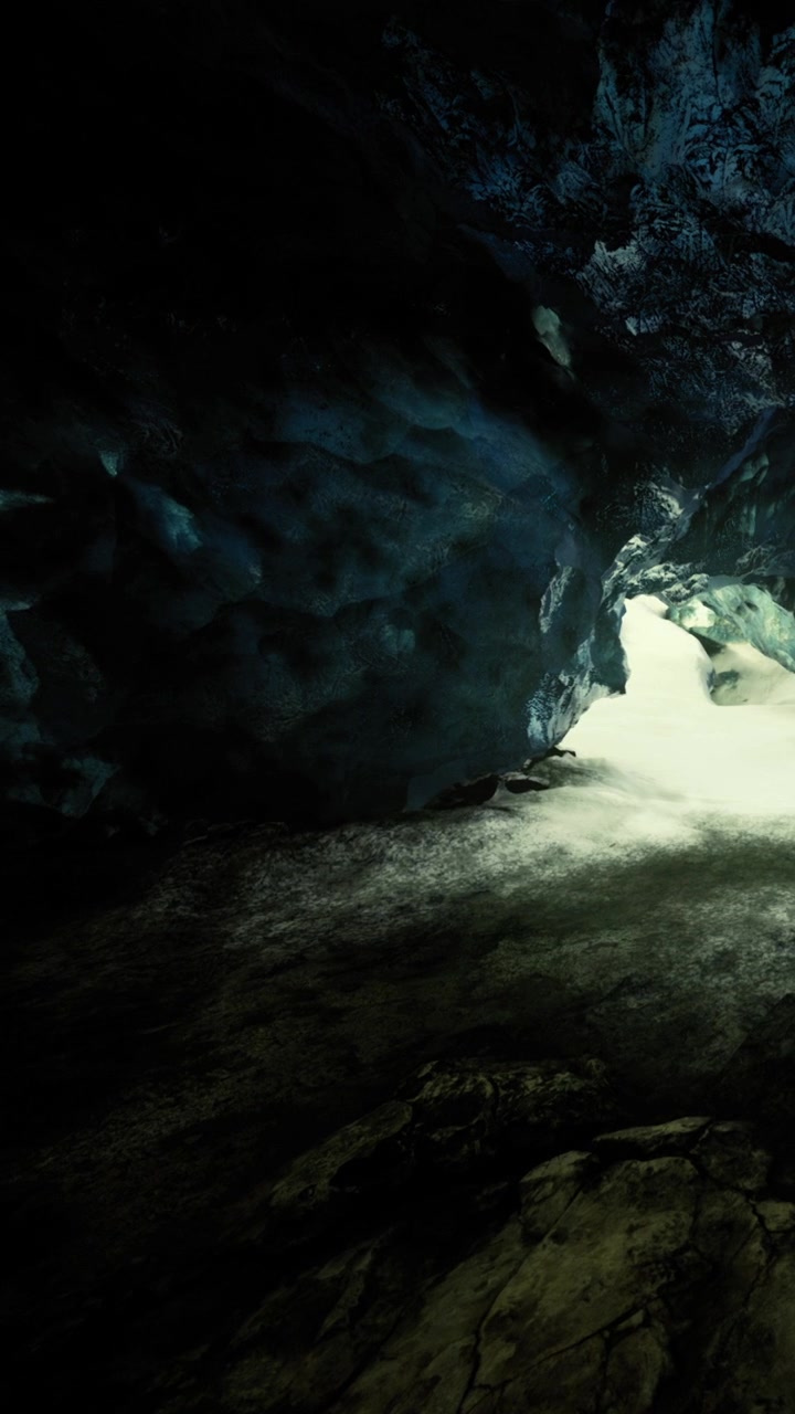 La luce splende all'interno di una grotta vicino a un ingresso roccioso durante il giorno