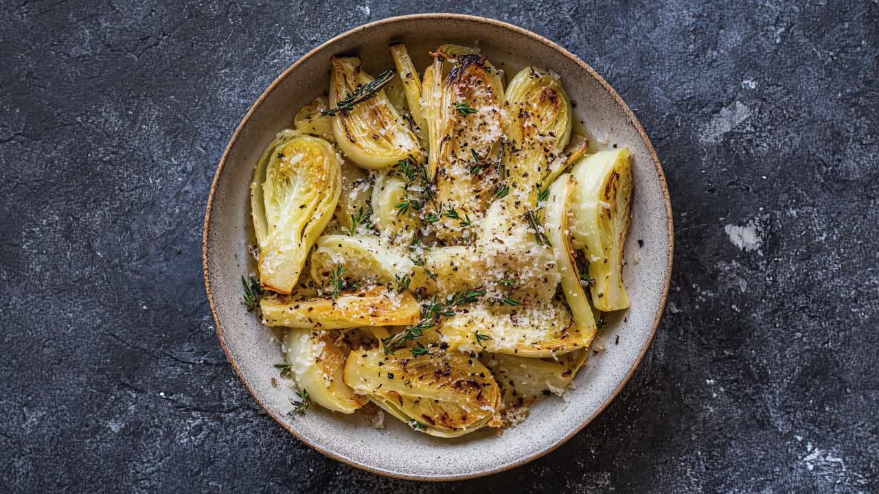 plato de hinojo asado con parmesán y hierbas frescas para adornar