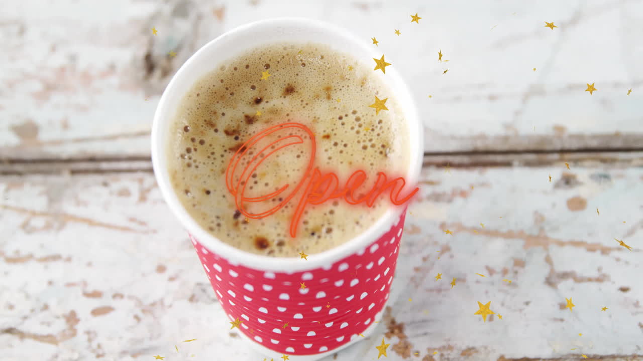 Red polka-dot cup filled with frothy coffee on table, gold confetti scattering, neon script glowing