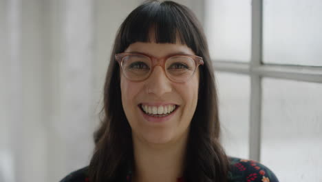 retrato de una mujer joven y elegante sonriendo alegremente con gafas funky disfrutando del estilo de vida de la ventana de fondo