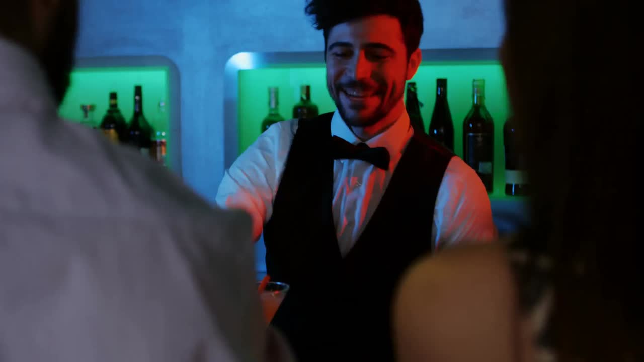 Barkeeper serviert Getränk an der Bartheke
