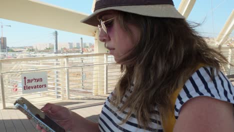 Woman Using Phone on Terminal Bridge