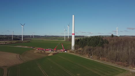 construction site of a wind turbine green energy generation - aerial drone shot push in