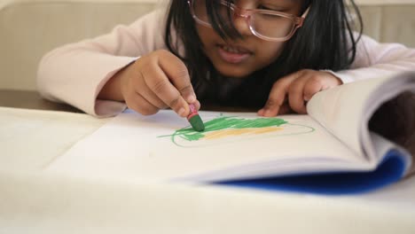 una niña coloreando en un libro