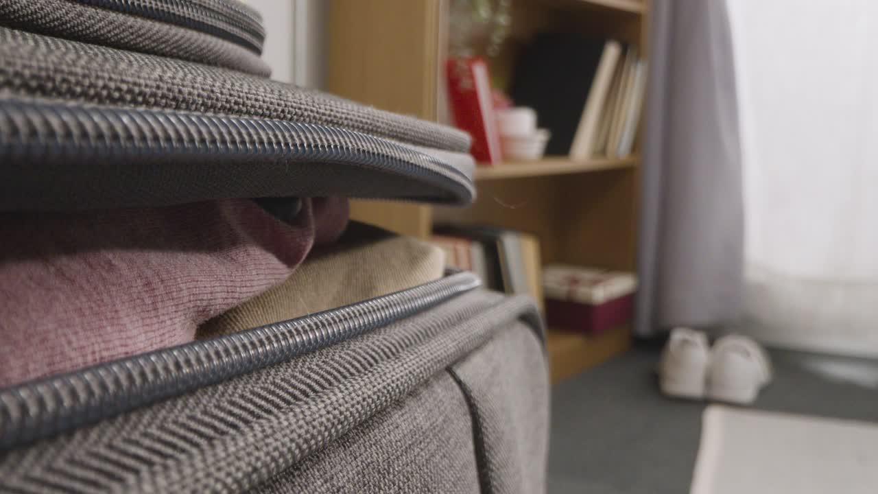 집 에 있는 사람 의 가까운 모습 여름 휴가 를 위해 준비 된 가방 을 닫고 지프 를  ⁇ 고 있다 1