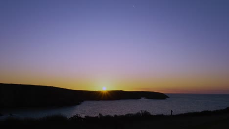 sun flare on horizon of coastline in pembrokeshire, wales. nature footage of sunset with silhouetted coast day comes to an end. natural light footage.