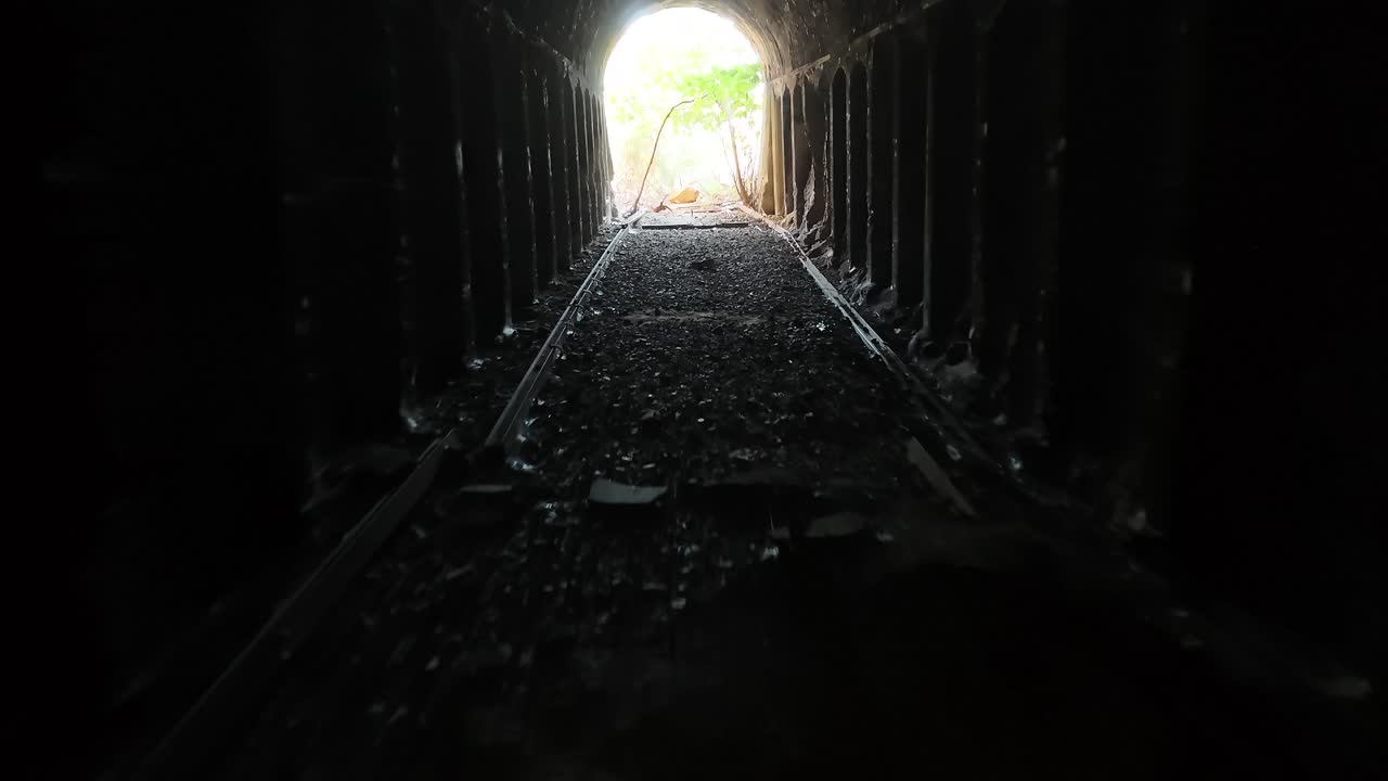 Abandoned railway tunnel towards the light at the exit