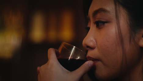 woman drinking red wine in a bar