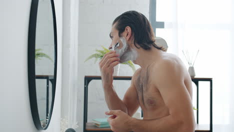 hombre afeitándose en el baño
