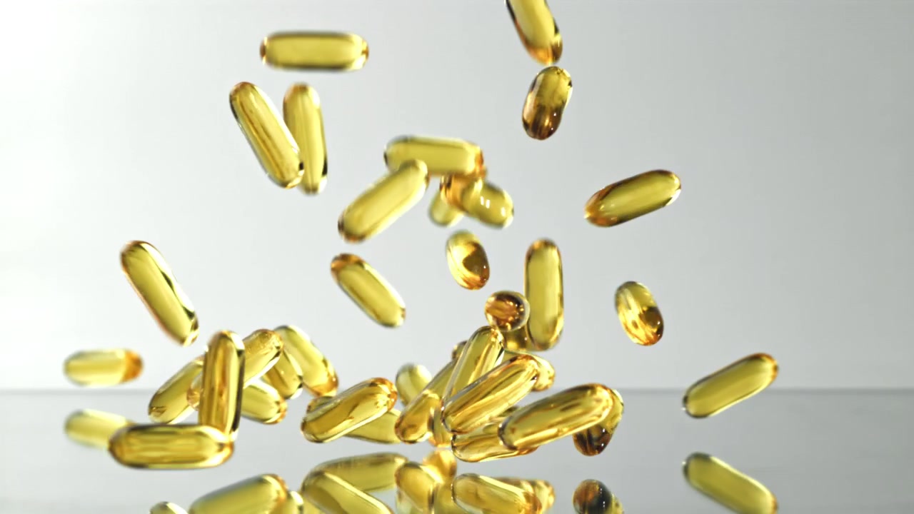 Capsule softgel dorate che cadono al rallentatore