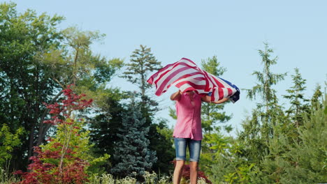 emotions with usa flag - young woman jumping holding a flag in her hands independence day and a trip