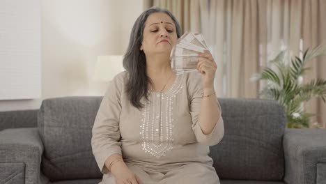 Confident-Indian-old-woman-using-money-as-fan