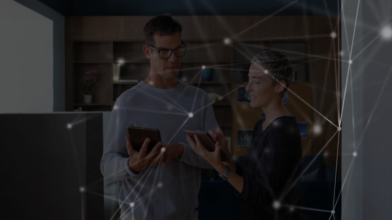 Man tapping tablet pulsing network while woman exchanging phone and reviewing digital data