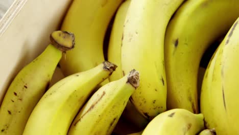 fresh bananas arranged in wooden crate