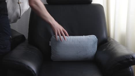 sacando almohadas de un sillón negro