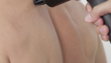 masaje con la pistola de masaje, en la espalda, cámara lenta