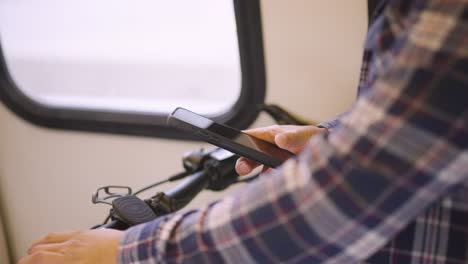a man is checking his phone while on the train.