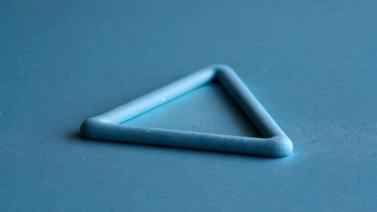 Zooming camera viewpoint showing matte blue triangular ring on blue sheet, revealing rim and dust