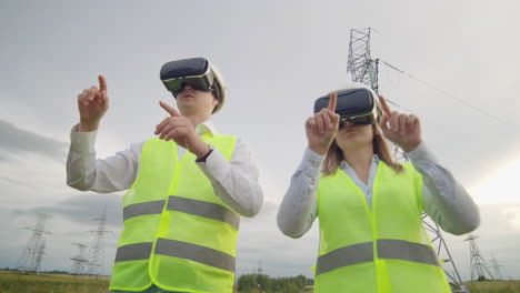 Dos-Ingenieros-De-Energía-Con-Gafas-Vr-Mueven-Las-Manos-Simulando-El-Funcionamiento-De-La-Interfaz-Del-Sistema-De-Control-Y-La-Planificación-De-Líneas-De-Alto-Voltaje-Para-El-Suministro-De-Electricidad-A-Partir-De-Fuentes-De-Energía-Alternativas.