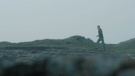 caucasian man walking near the coast