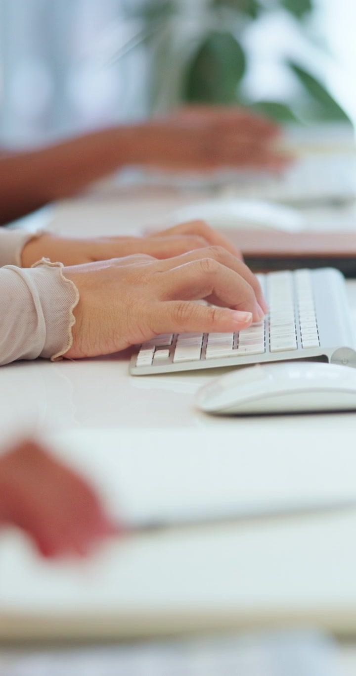 Close-up of Hands Typing on Computer Keyboard in Office