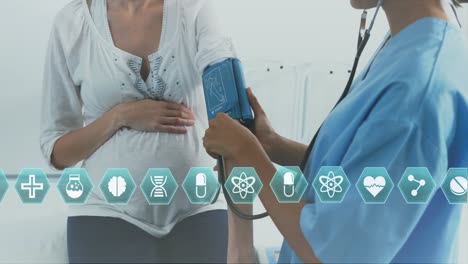 animation of medical icons over pregnant caucasian woman having blood pressure checked by midwife