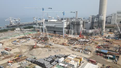 cranes and equipment working at development site of power station