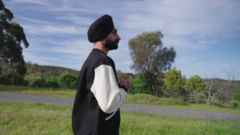 portrait of a punjabi sikh man surrounded by evergreen nature landscape during daytime