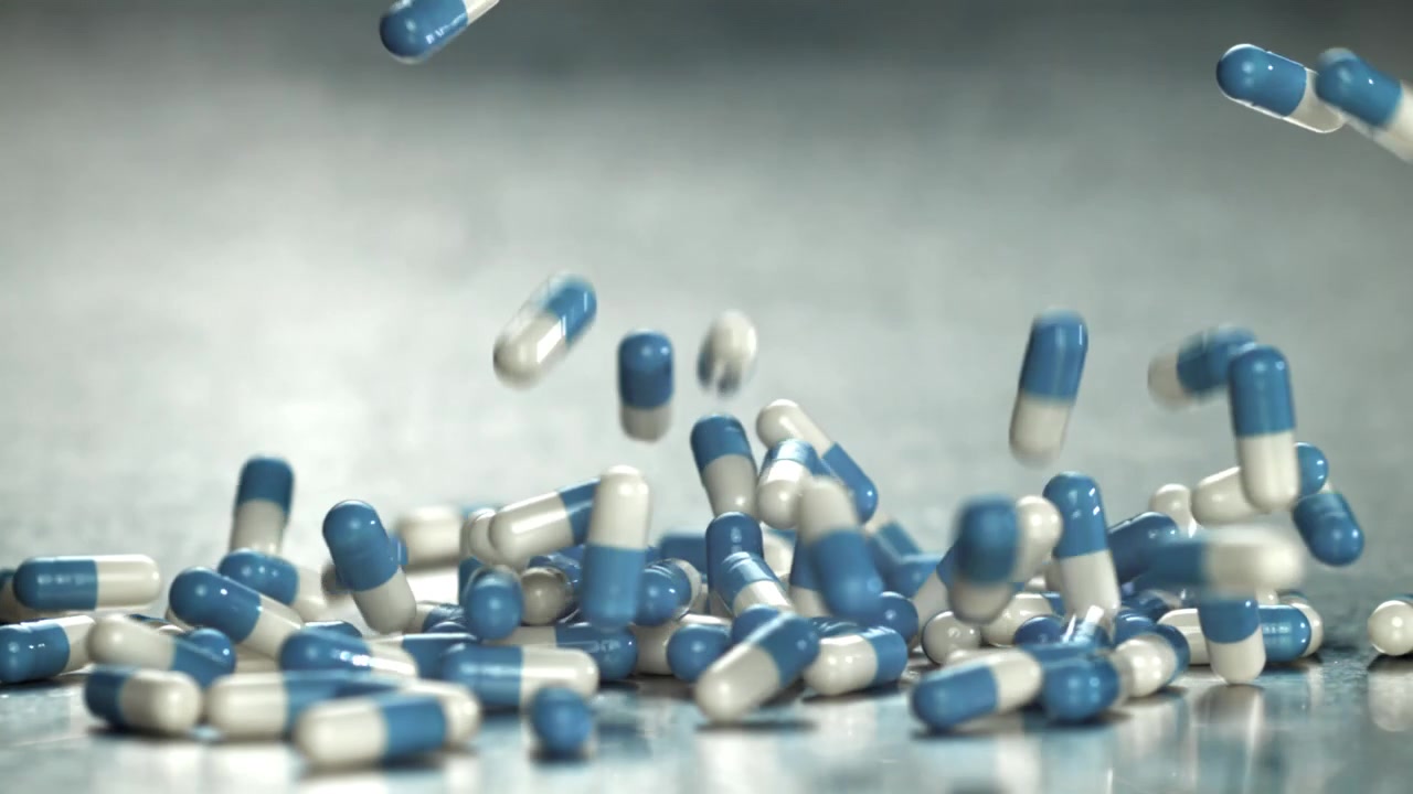 Capsule mediche blu e bianche che cadono al rallentatore