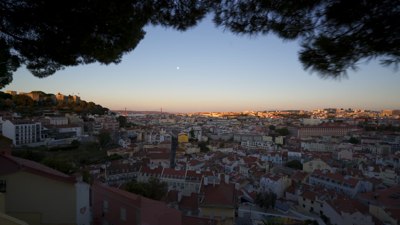 Una ragazza sta scattando una foto all'alba sull'Alfama a Lisbona, Portogallo