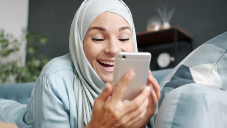 woman using phone on sofa