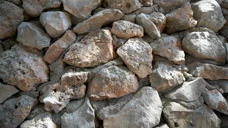 tobogán de carro hacia abajo, pared de piedras grandes sin cortar con cemento visible entre las piedras