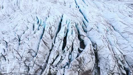 frozen ice shove with black cracks and crevasses in glacier in iceland