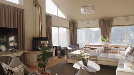 panning shot of furnished lounge and dining room with large sunny windows, copy space, slow motion