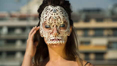 a woman with ornate venetian skull mask over face