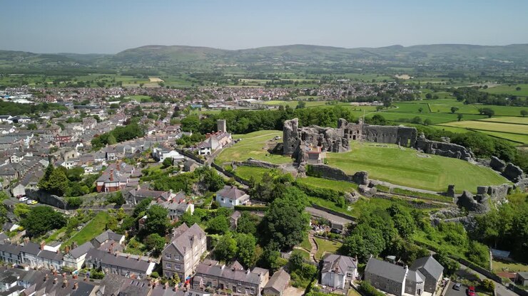 Denbigh Castle and Town Walls, Denbighshire, Wales - Aerial drone anti-clockwise distant pan from side to rear - June 23
