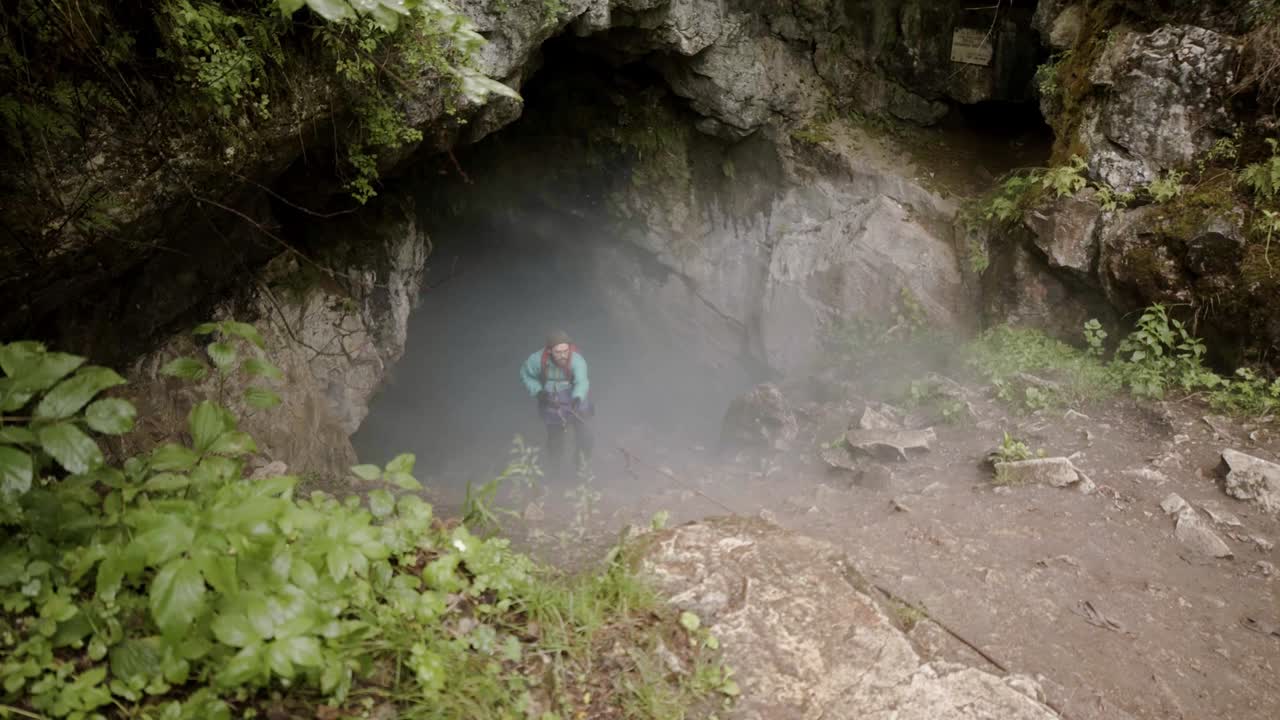 aventurero explorando una cueva en un bosque de niebla