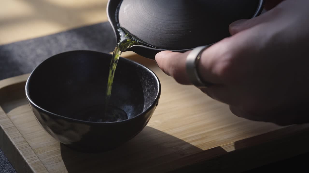 Green tea Sencha steeping in hot water during a traditional ceremony, prepared in a shiboridashi teapot