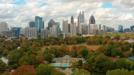 Descending-before-downtown-Atlanta,-Georgia-with-Piedmont-Park-and-public-pool