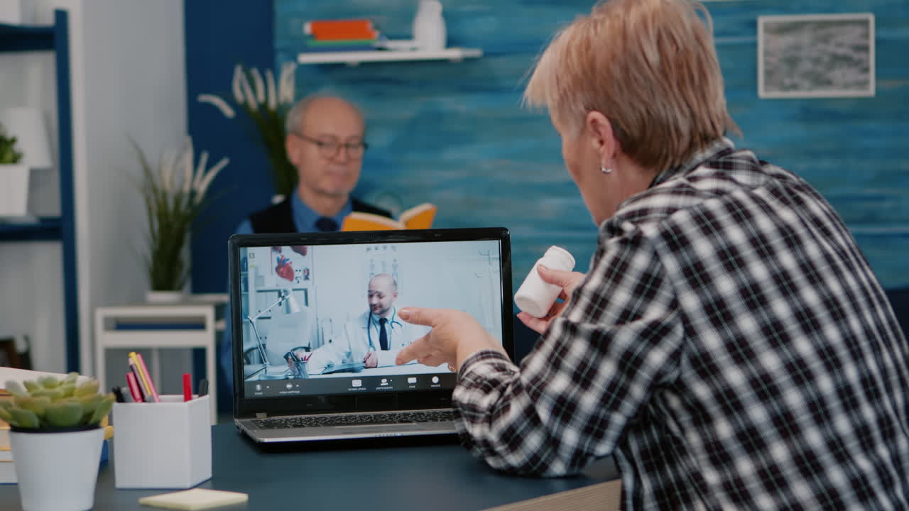 Young male doctor talking to senior female patient by tele medicine online